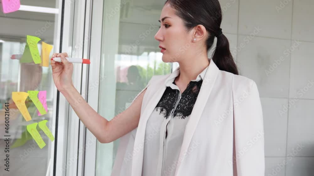 Asian business people meeting in office and use post it paper notes to share idea. Start up team brainstorming concept Asian business people meeting in office and use post it paper notes to share idea. Start up team brainstorming concept