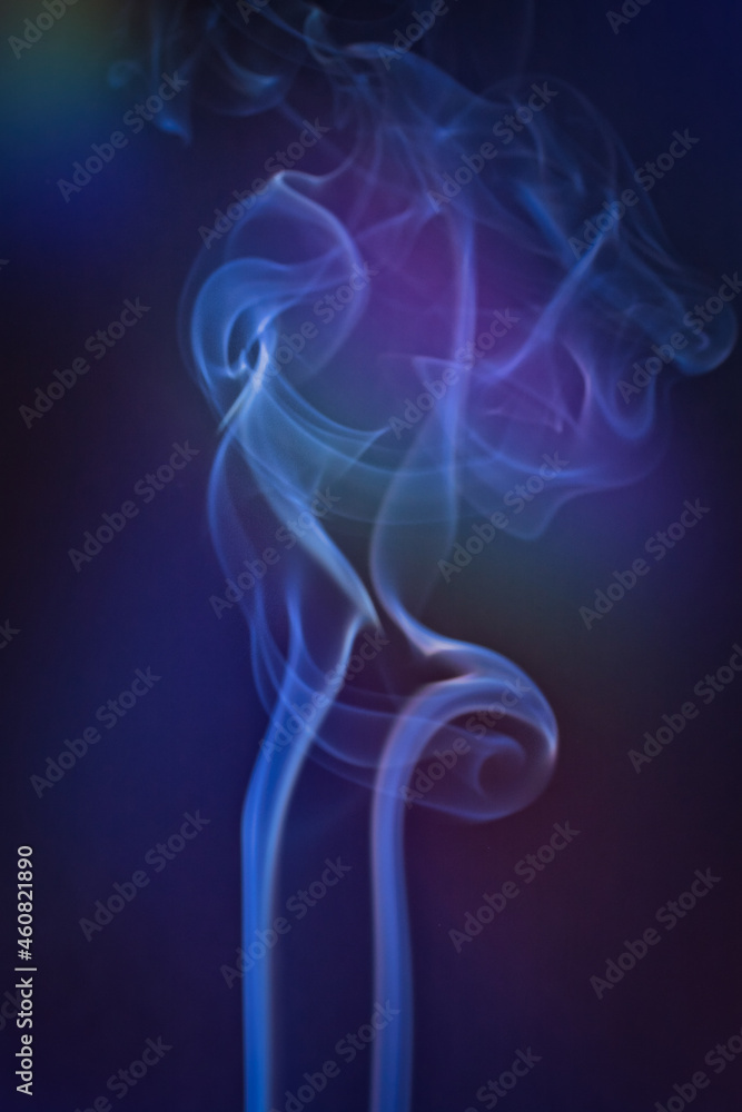 A vertical shot of smoke in colorfull backlight with a blue note A vertical shot of smoke in colorfull backlight with a blue note