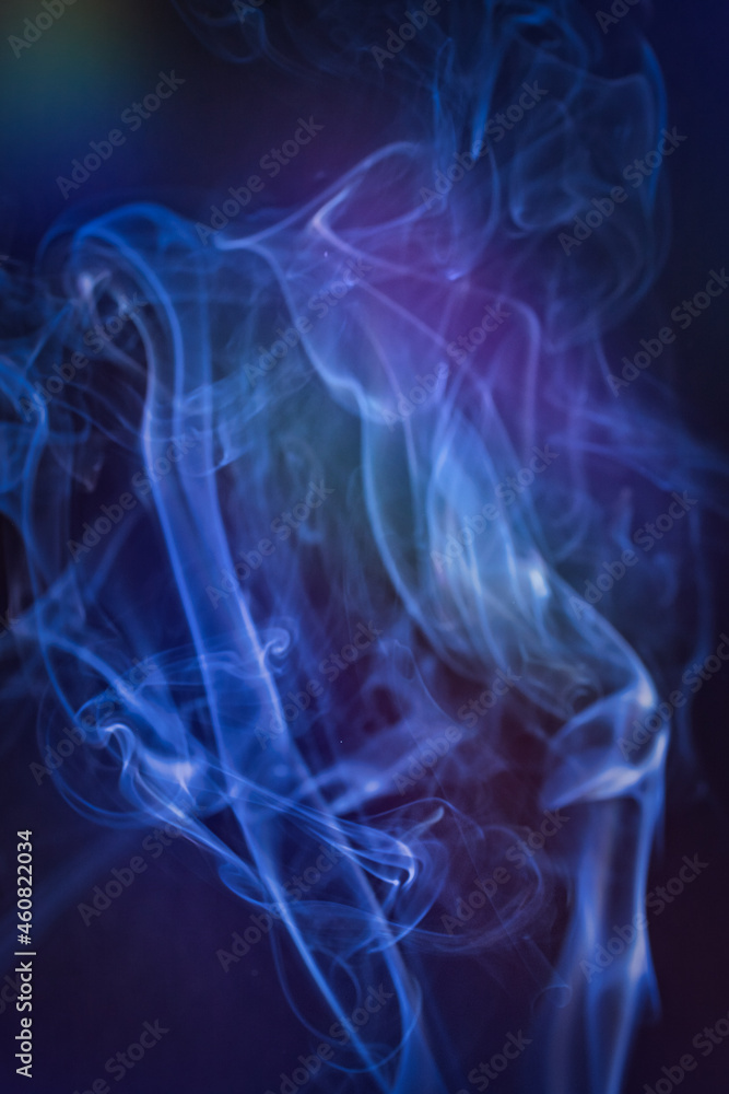 A vertical shot of smoke in colorfull backlight with a blue note A vertical shot of smoke in colorfull backlight with a blue note