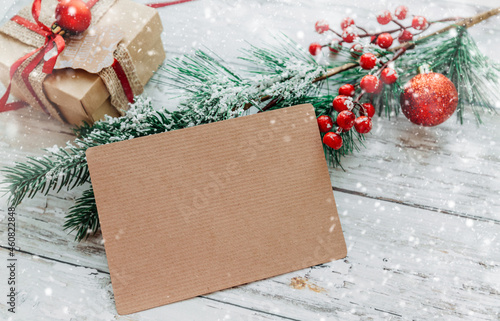 Christmas toys, gifts with a craft card for inserting text on a light wooden background with snowflakes. copy space.	