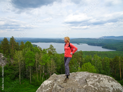 The woman is standing on the top of the mountain. Tourism, travel, action Mount Arakulskie Shikhany, Chelyabinsk region, Russia.