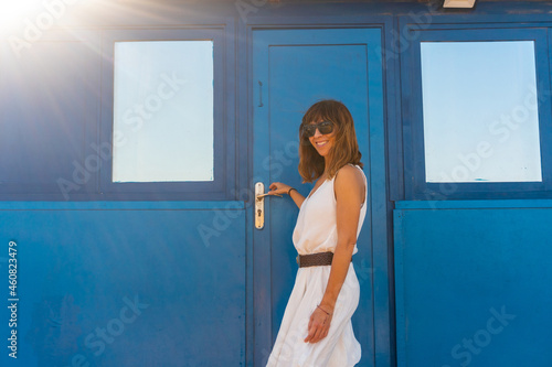 A tourist in a white dress in a blue house in the fishing village of Majanicho, north of the island of Fuerteventura, Canary Islands. Spain photo