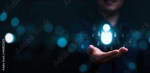 Businessman holding virtual human icon for focus customer group or human recruitment and development concept. photo