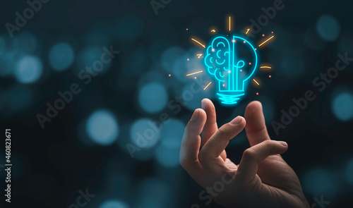 Hand holding drawing virtual lightbulb with brain on bokeh background for creative and smart thinking idea concep photo