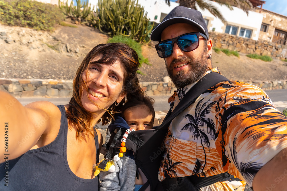 Φωτογραφία A father with his son in his backpack and the mother on vacation on the beach of Ajuy, Pajara, west coast of the island of Fuerteventura, Canary Islands