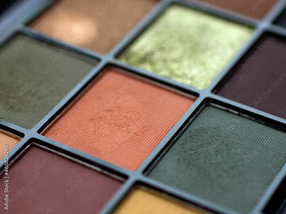 Fototapeta premium Make-up eye shadow palette close up. Professional multicolor eyeshadow palette. Makeup. Professional multicolor eyeshadow make up palette background. Colorful bright eye shadows set backdrop