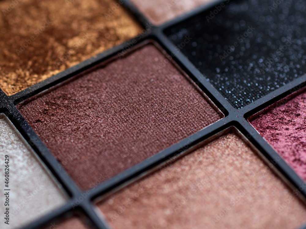 Fototapeta premium Make-up eye shadow palette close up. Professional multicolor eyeshadow palette. Makeup. Professional multicolor eyeshadow make up palette background. Colorful bright eye shadows set backdrop