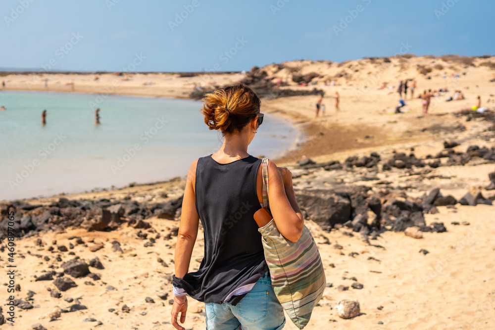 A young tourist visiting La Concha beach on Isla de Lobos, next to the north coast of the island of Fuerteventura, Canary Islands. Spain