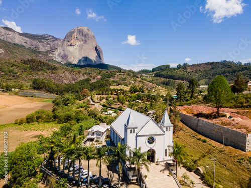 Foto Visão aérea da Pedra Azul, com vegetação, casas, vilarejo e igreja