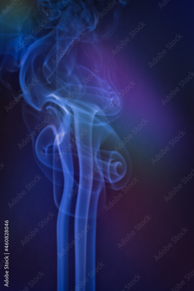 A vertical shot of smoke in colorfull backlight with a blue note A vertical shot of smoke in colorfull backlight with a blue note