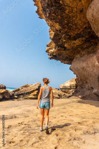 A young woman walking along the sea in Playa de Garcey, west coast of Fuerteventura, Canary Islands. Spain photo