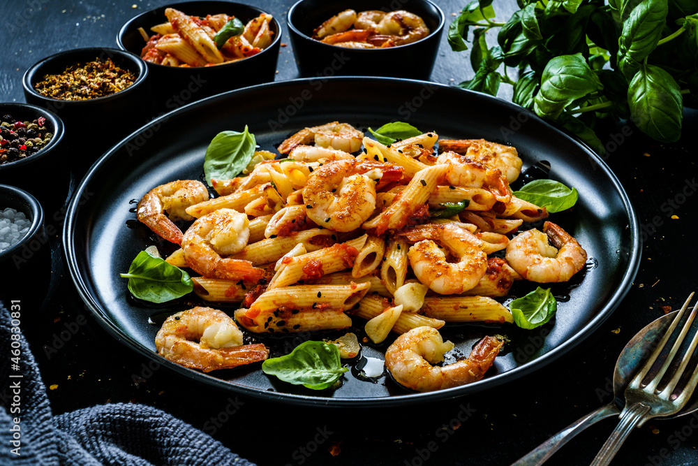 Penne with fried prawns in on black wooden background
Penne with fried prawns in on black wooden background