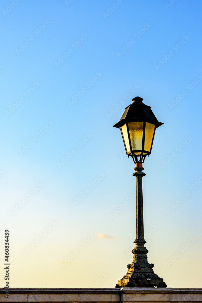 Old colonial style lamppost on the walls of the streets of Salvador, Bahia during summer sunset.