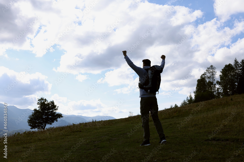 Triumphant tourist on top of mountain, back view. Space for text Triumphant tourist on top of mountain, back view. Space for text