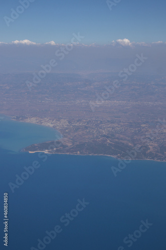 View from the plane. Natural landscape and cumulus clouds. Sea view from above. Beautiful blue sea and sky © Ekaterina