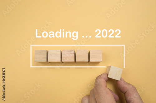 Wooden cube message 2021 - 2022 download yellow background. Block wood letter 2021 to 2022 load happy new year. top view. 