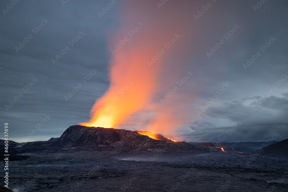 Fototapeta premium Night volcanic eruption. Fresh hot lava, flames and poisonous gases going out from the crater.