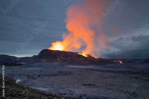 Night volcanic eruption. Fresh hot lava, flames and poisonous gases going out from the crater.