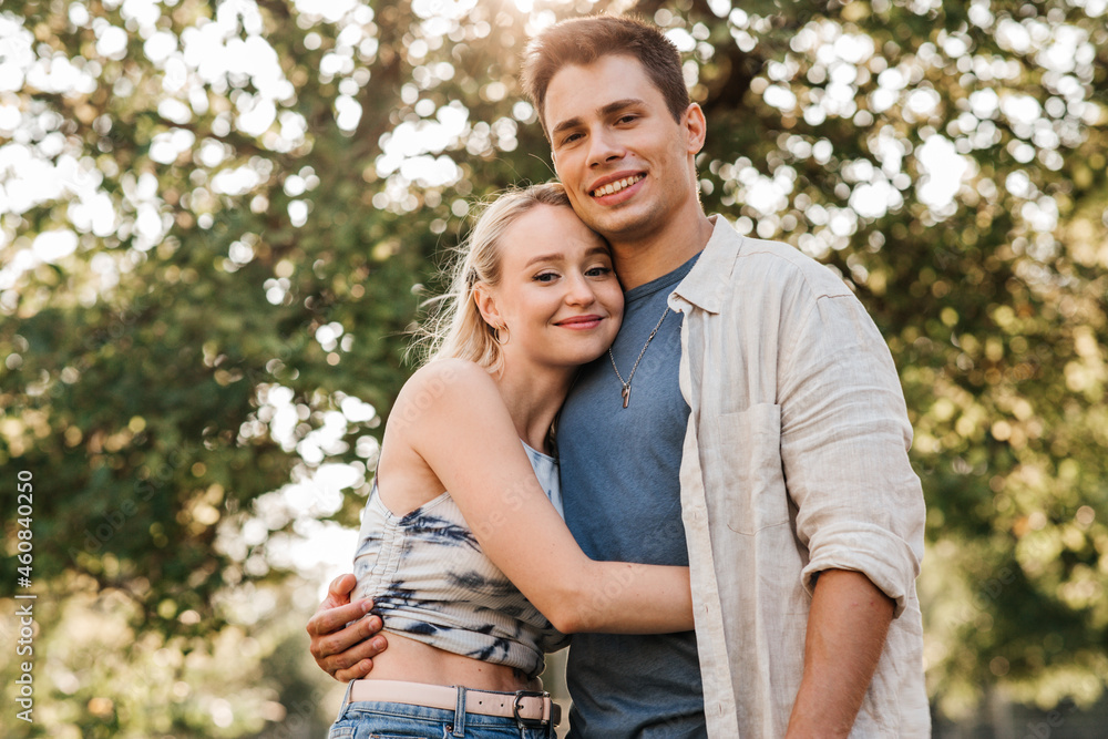 summer holidays, love and people concept - happy young couple hugging outdoors summer holidays, love and people concept - happy young couple hugging outdoors