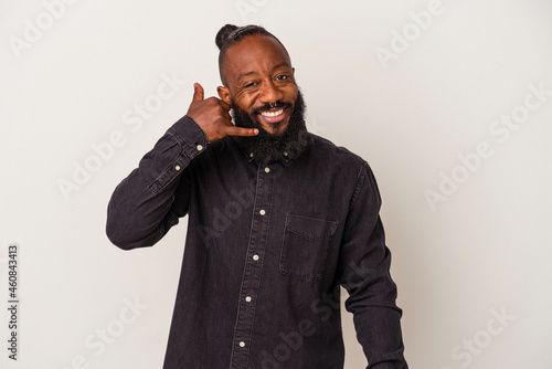 African american man with beard isolated on pink background showing a mobile phone call gesture with fingers.