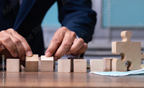 Businessman hand flipping wooden cubes and mask.