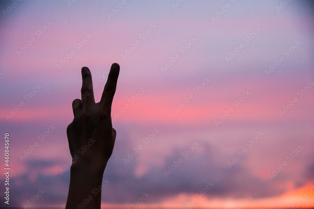 silhouette of a person hand with v shape of sign in the sunset silhouette of a person hand with v shape of sign in the sunset