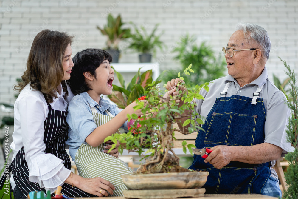 Fototapeta premium Happy family gardening together in the garden, grandfather grandson and woman taking care of nature