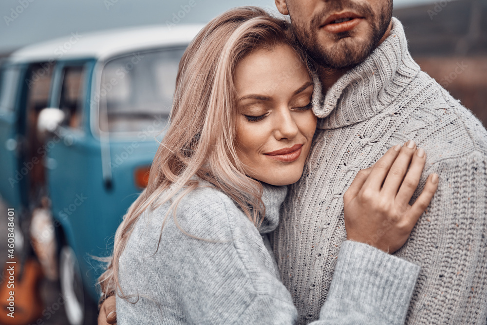 Beautiful young loving couple embracing while spending time near their retro minivan outdoors - obrazy, fototapety, plakaty 