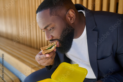 A dark-skinned maneating snadwich with a big appetite photo