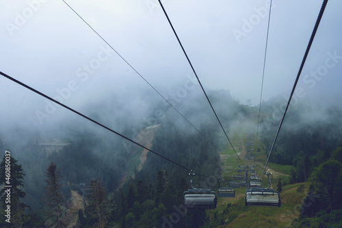 Cable car in the mountains with clouds or fog.View from the cable car to the mountain landscape.The Caucasus Mountains.without people, suitable for advertising outdoor activities and sports.copy space