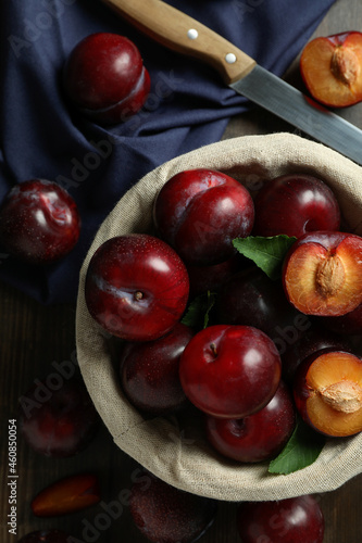 Concept of tasty food with plums on a wooden table