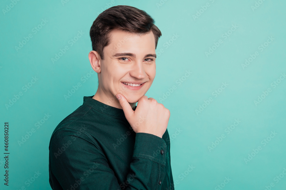 Portrait of minded young business man touch finger face thinking isolated over teal background