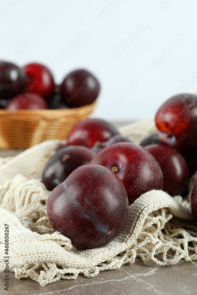 Concept of fruits with plums on gray textured table Concept of fruits with plums on gray textured table