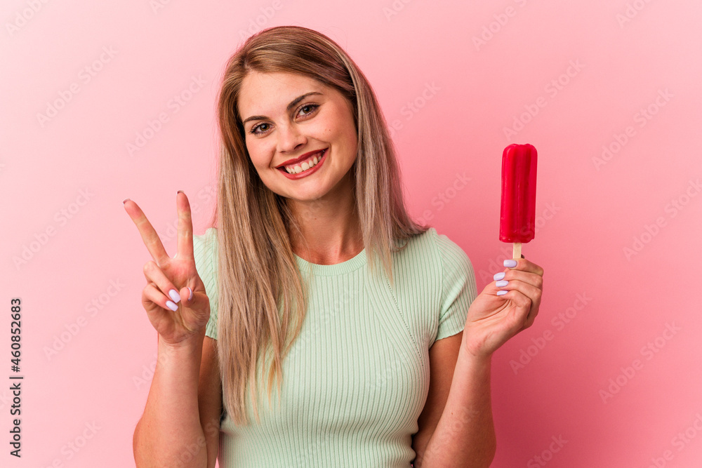 Young russian woman holding an ice cream isolated on pink background showing number two with fingers. Young russian woman holding an ice cream isolated on pink background showing number two with fingers.