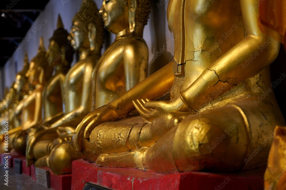 Old Buddha images lined up in rows and traces of damage
