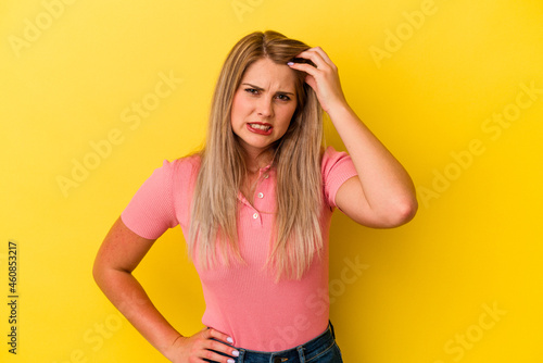 Young russian woman isolated on yellow background forgetting something, slapping forehead with palm and closing eyes.