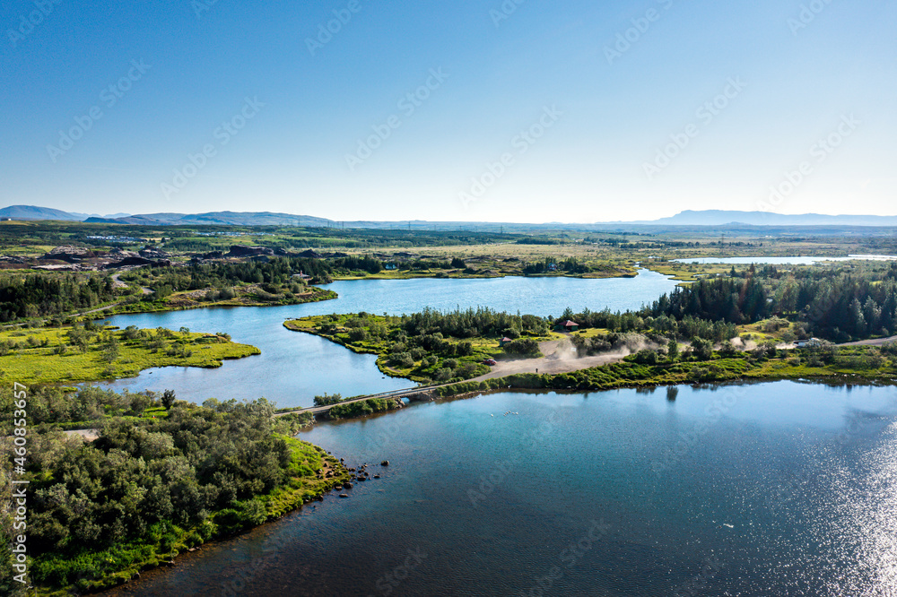 River flowing between green shores connected with bridge