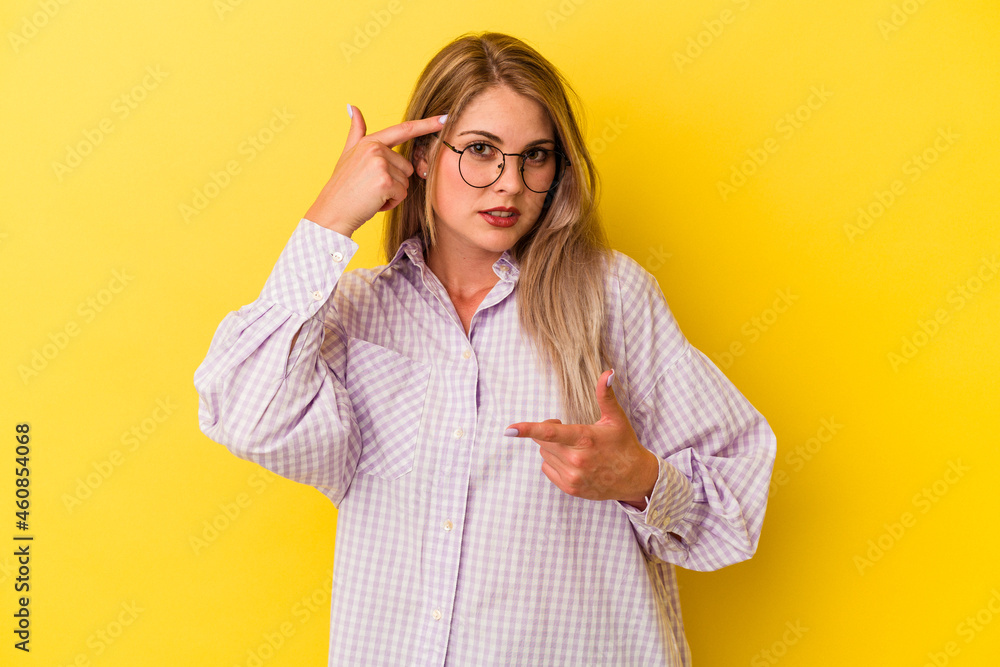 Young russian woman isolated on yellow background showing a disappointment gesture with forefinger. Young russian woman isolated on yellow background showing a disappointment gesture with forefinger.