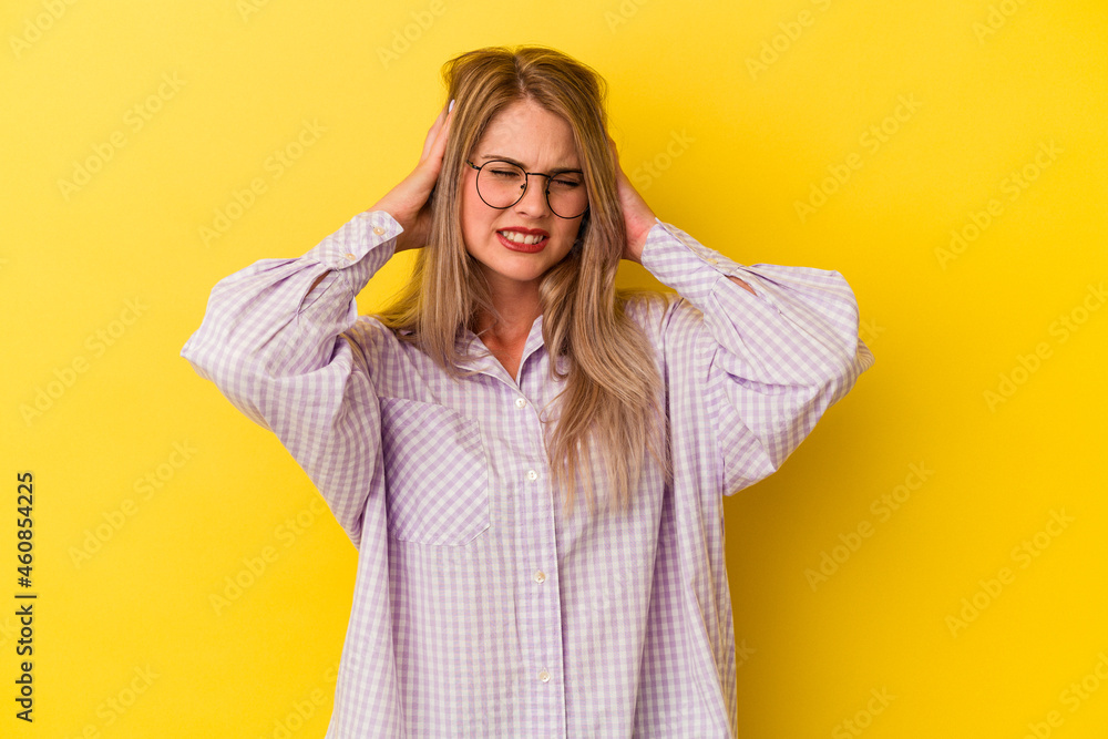 Young russian woman isolated on yellow background covering ears with hands. Young russian woman isolated on yellow background covering ears with hands.
