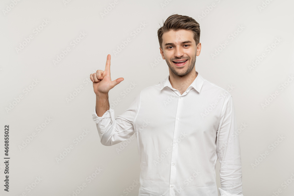 Young handsome man over isolated white background showing two fingers while smiling confident and happy