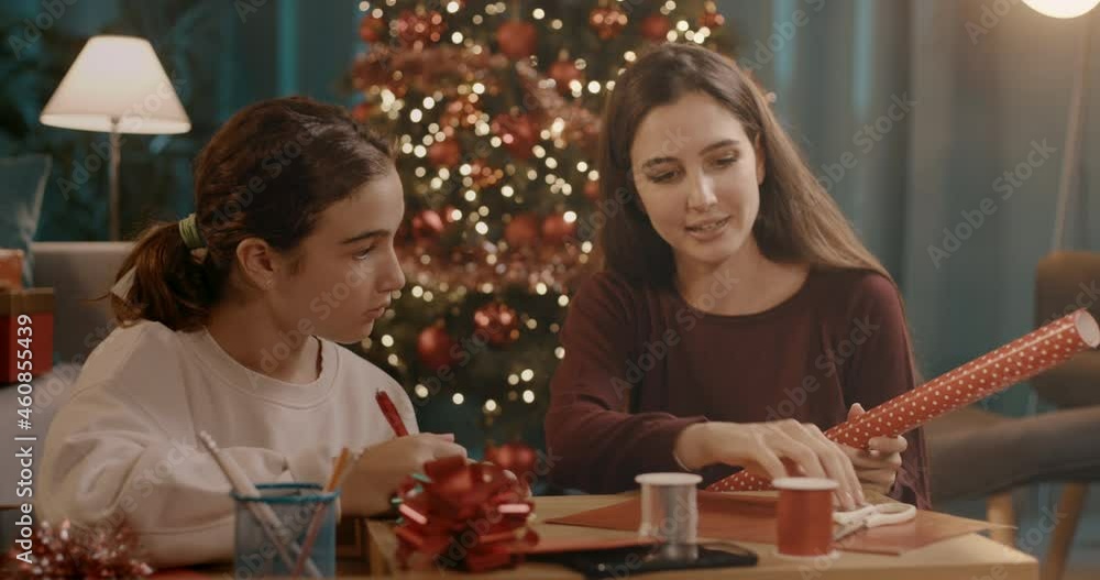 Sisters preparing Christmas gifts together Sisters preparing Christmas gifts together