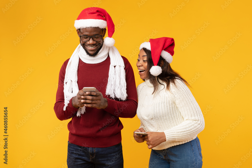 Fototapeta premium Excited Girlfriend Looking At Boyfriend's Smartphone While He Texting, Studio