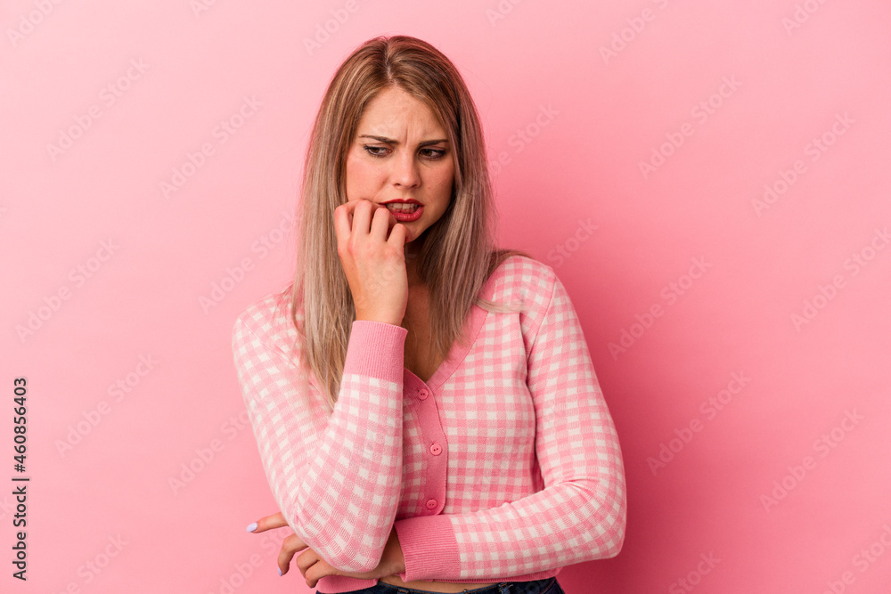 Young russian woman isolated on pink background biting fingernails, nervous and very anxious. Young russian woman isolated on pink background biting fingernails, nervous and very anxious.