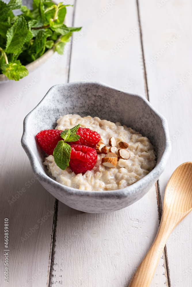 Bowl with cereal porridge decorated with raspberries and mint Bowl with cereal porridge decorated with raspberries and mint