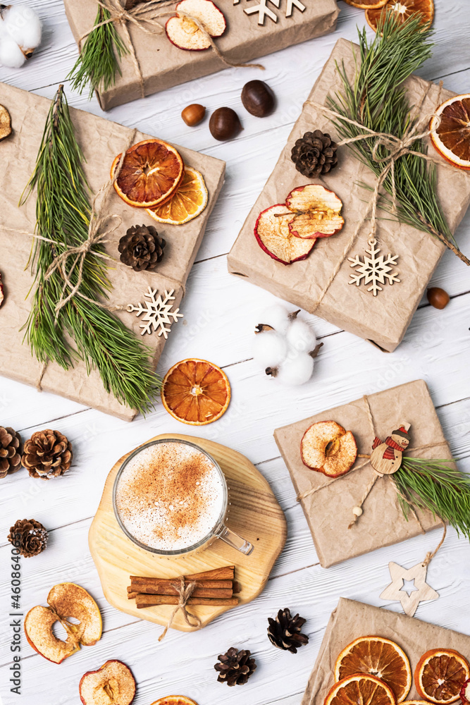 Cup of Latte Coffee with Cinnamon and Christmas presents, decorated dried fruits, pine cones and fir branches. Cozy winter holiday background. Cup of Latte Coffee with Cinnamon and Christmas presents, decorated dried fruits, pine cones and fir branches. Cozy winter holiday background.