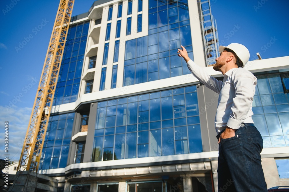 A construction worker control in the construction of roof structures on construction site and sunset background A construction worker control in the construction of roof structures on construction site and sunset background