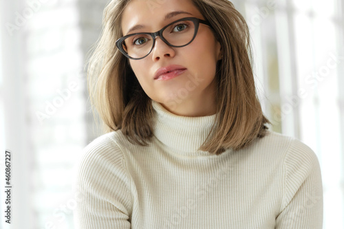Woman with poor eyesight. A beautiful girl wears glasses to improve her vision. High quality photo