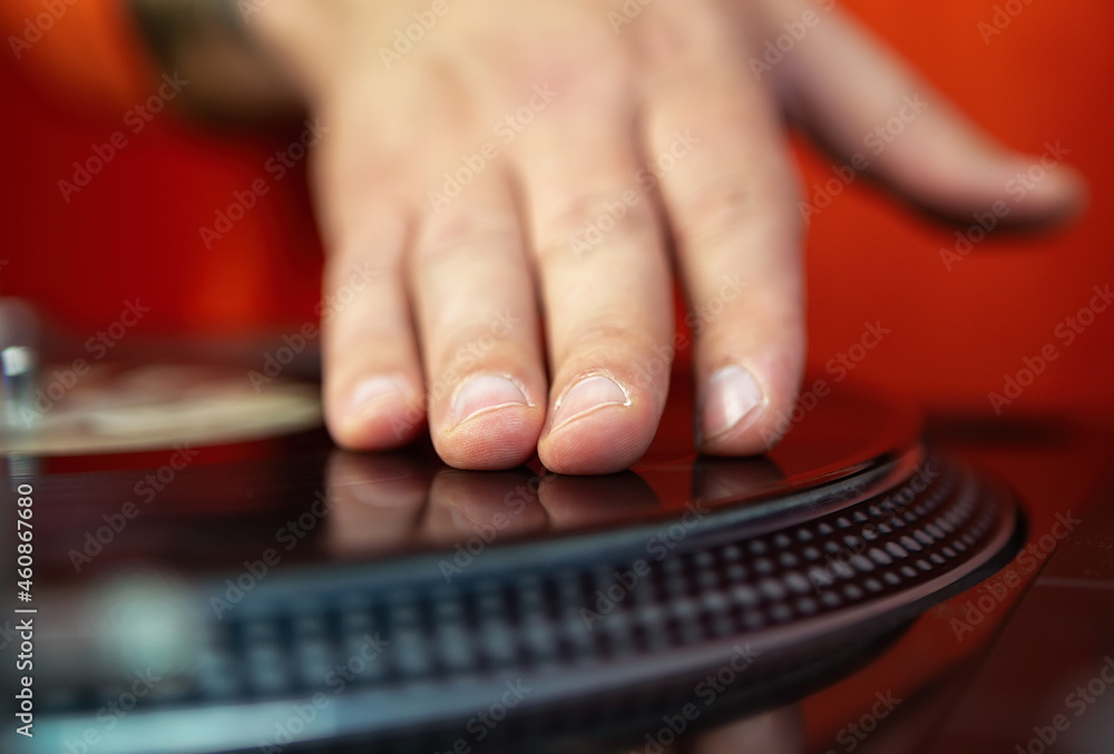 Hand of dj playing hip hop music with turntables and vinyl records. Professional analog audio equipment for disc jockey Hand of dj playing hip hop music with turntables and vinyl records. Professional analog audio equipment for disc jockey