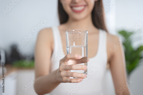 Woman smiling and holding a glass of mineral water