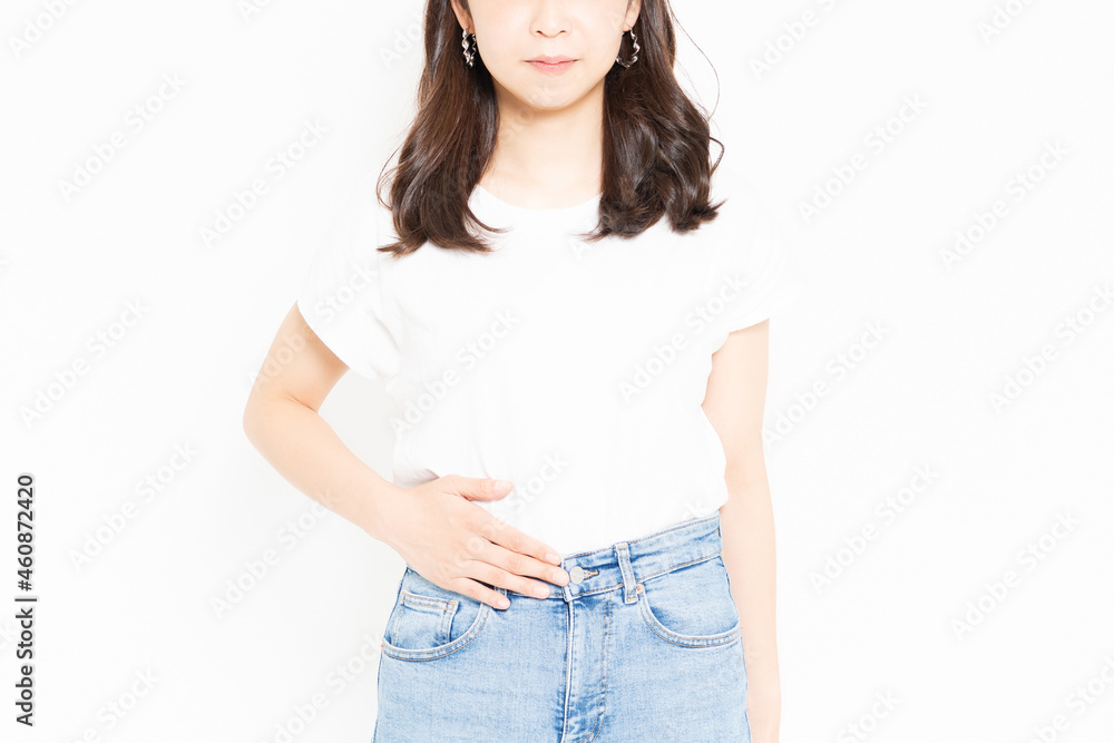 Obraz premium お腹に手を当てるTシャツを着た若い女性